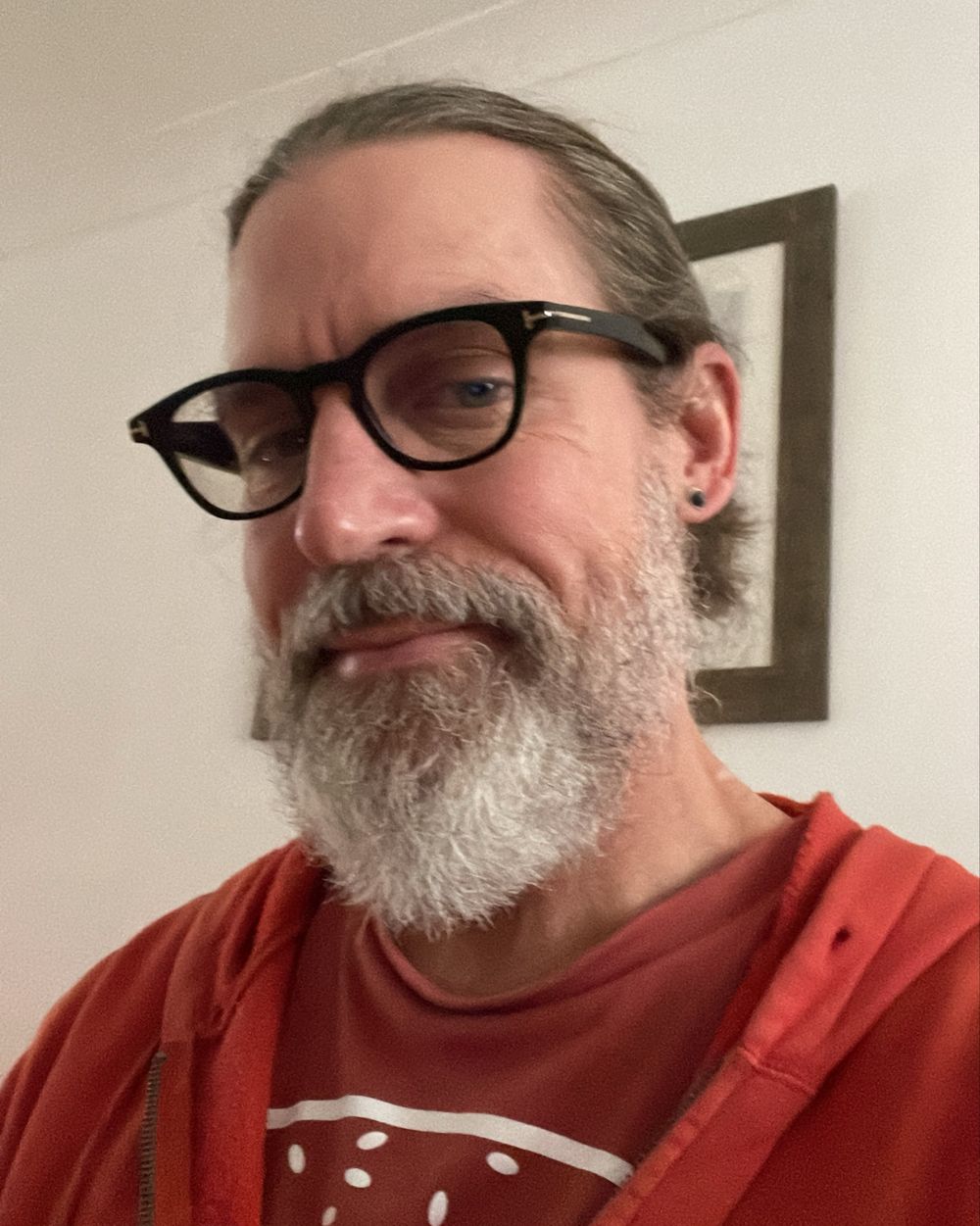Jason Goveia, smiling, with a grey beard and dark-rimmed glasses